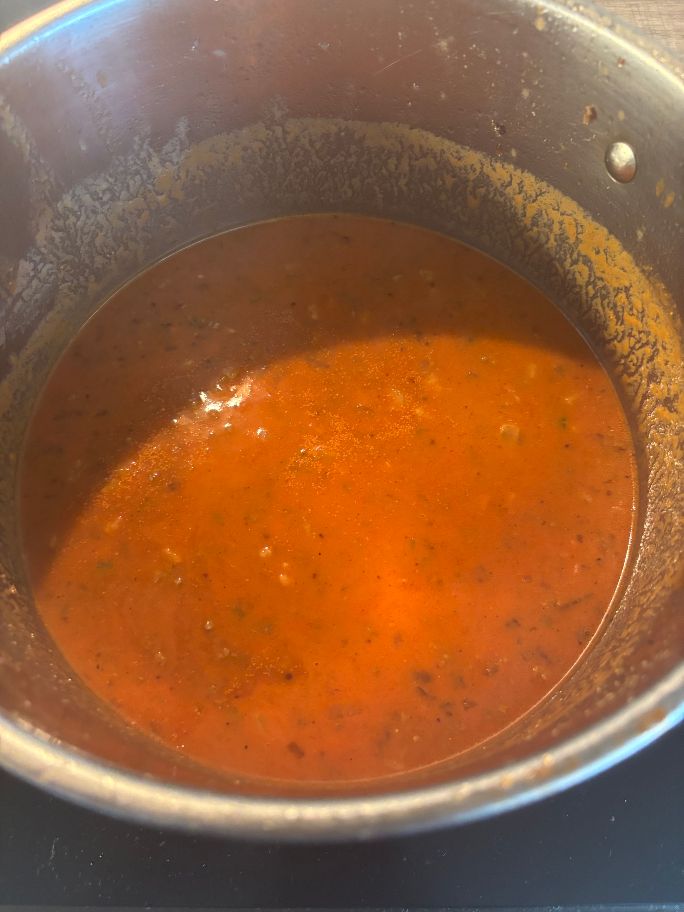 Mit Milch und Passierten Tomaten aufgefüllter Topf